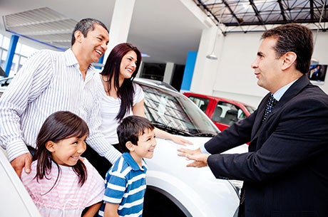 Couple shaking hands with Sales Person
